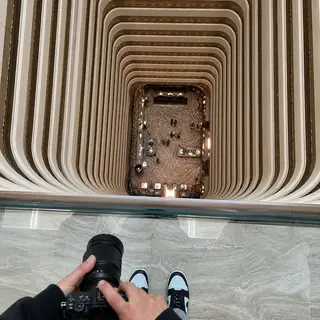 Balcony Scale Shot. Get a vertigo-inducing shot straight down a hotel atrium — never leaning or blocking.